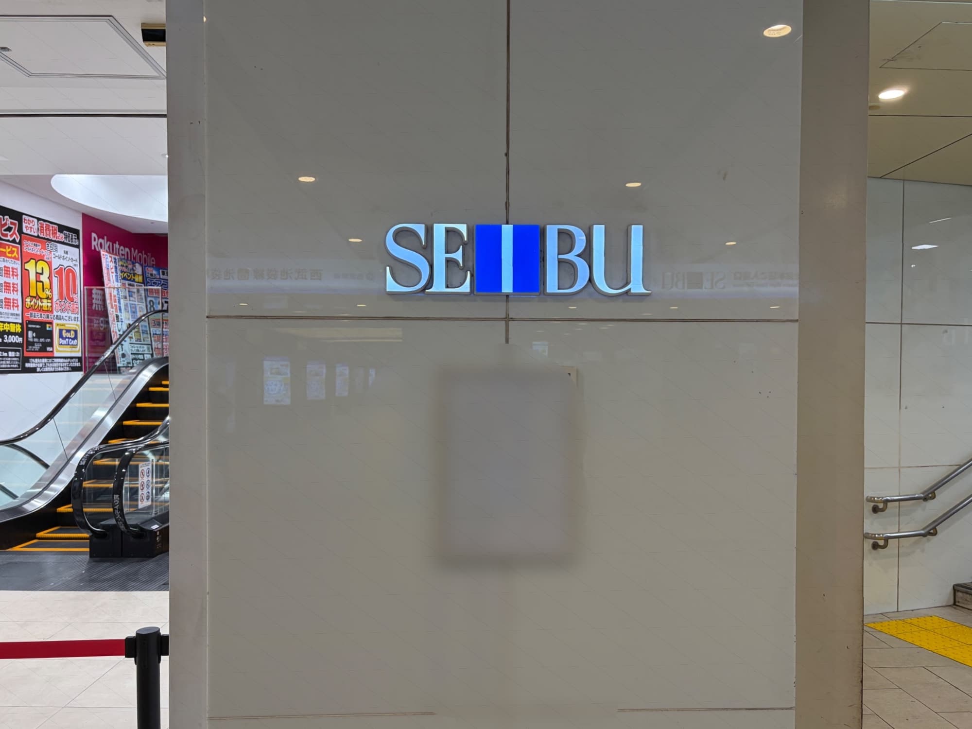 旧アゼリア口右側のSEIBUマーク。ここの入店口の扱いは難しいが、ひとまず左側が西武、右側がヨドバシっぽい分け方がされてる中、右側についているSEIBUマークも光るのですね。
文句なく西武区画の旧おかず市場口のSEIBUサインは発光していないのに…。不思議ですね。