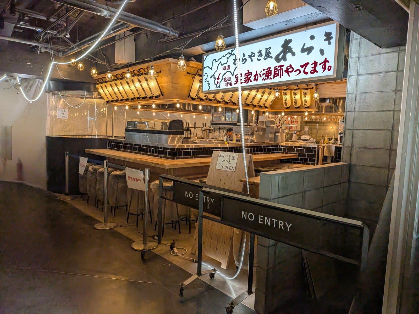8階「ダイニングパーク池袋」ラ・ベットラ・ダ・オチアイから西武池袋本店へ向かう通路左側一部の仮囲いが外れ、「わらやき屋 あらき」が出現しました。
1枚目写真の通り、手書きで7月3日(金)オープンであることが告知されています。
以前私がSNAP!した旧中央ゾーンB8付近(4枚目写真)がダイニングパーク池袋と西武池袋本店の境界かと思っていましたが、この店舗奥に写る自動ドアが境界なのかもしれません。
